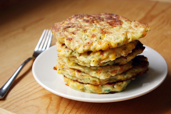 stack of zucchini corn pancakes on plate with fork