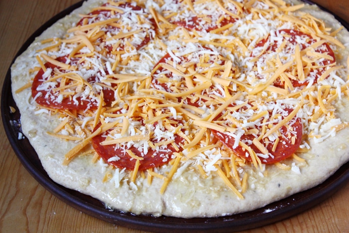 preparing pizza ingredients on the dough