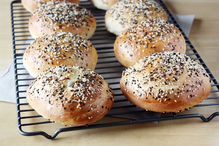 brioche hamburger buns with seeds on cooling rack