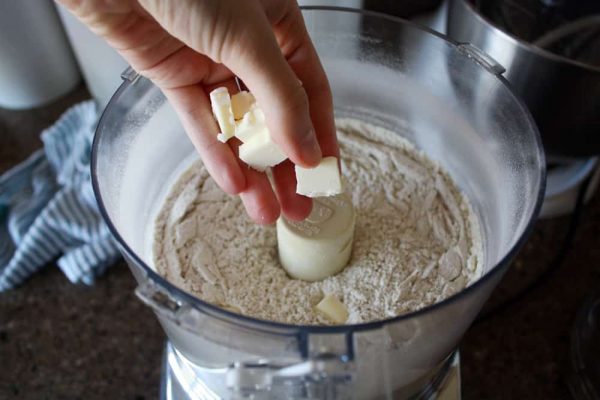 adding cubes of butter to cracker dough in blender.