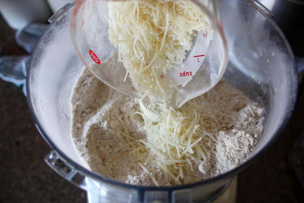 adding parmesan cheese to the cracker dough in blender