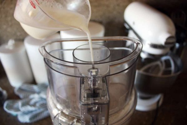 adding more ingredients to the cracker dough in blender.