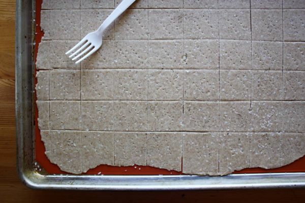 cutting cracker dough on baking sheet.
