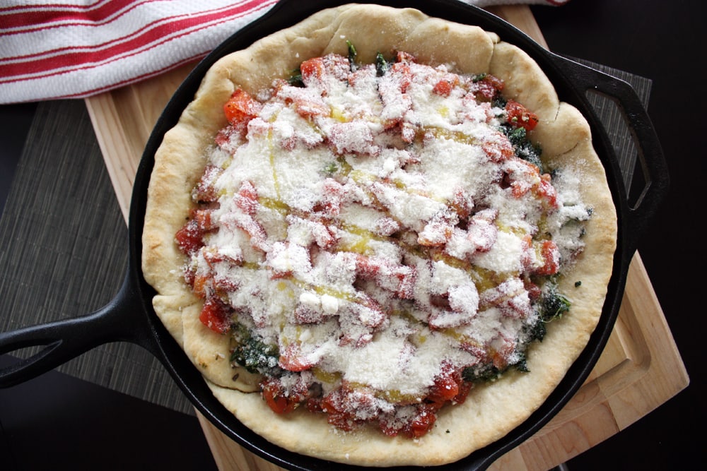 deep dish spinach tomato pizza ready for baking