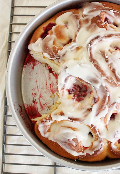 raspberry cinnamon rolls with thick filling and frosting.