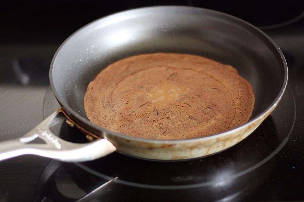 making chocolate crepe in pan on stove