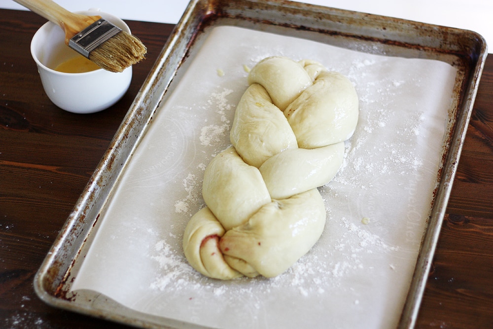 braided challah dough on baking sheet