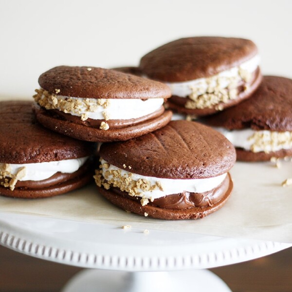 double chocolate s'mores whoopie pies on a cake stand.