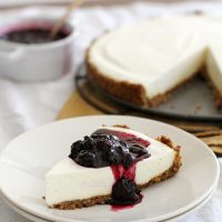 slice of lemon ginger panna cotta cheesecake with blueberry sauce