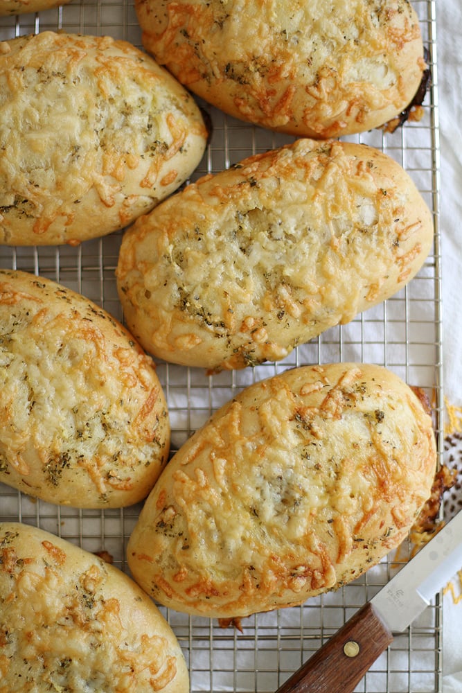 baked asiago herb hoagie rolls on cooling rack