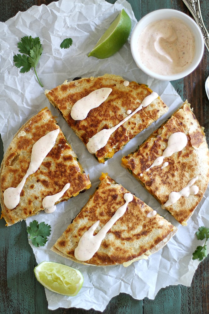 quesadilla on parchment paper with crema drizzled