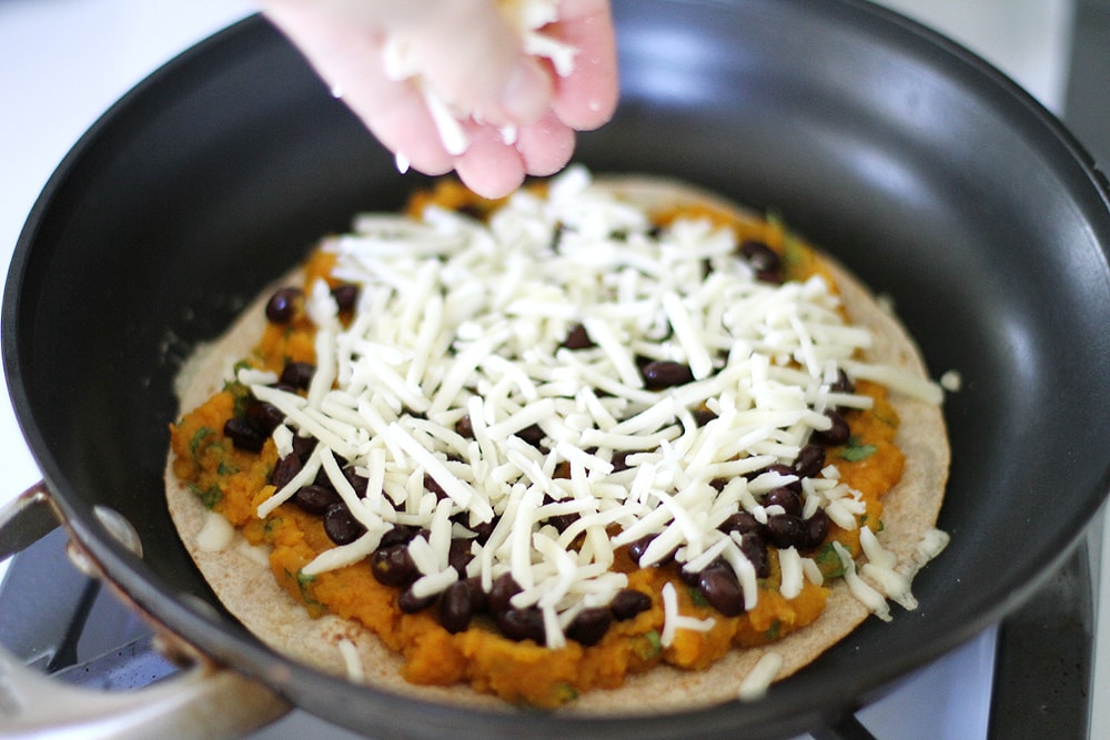 making quesadilla in pan on stove