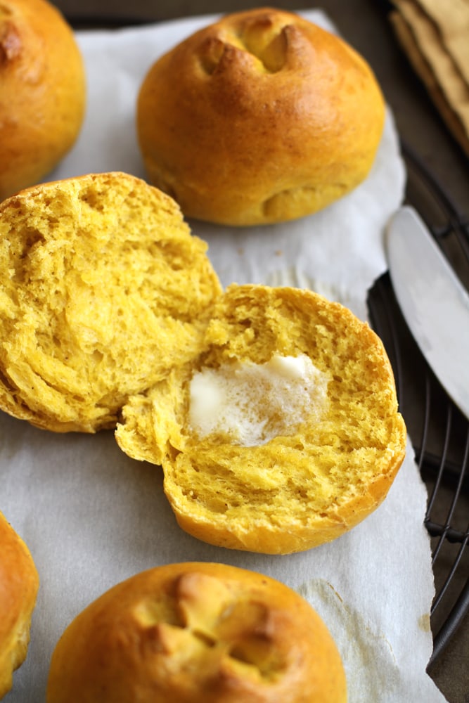 close up pumpkin brioche roll with pat of butter