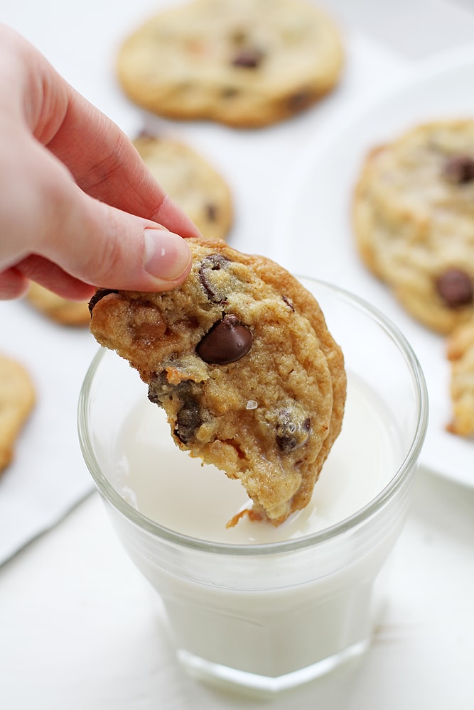 dunking caramel coconut chocolate chip cookie in milk