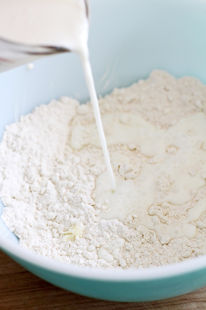 pouring buttermilk into flour mixture in bowl