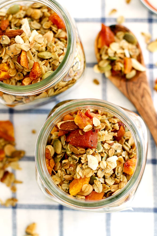 ginger peach granola in glass jar on kitchen towel