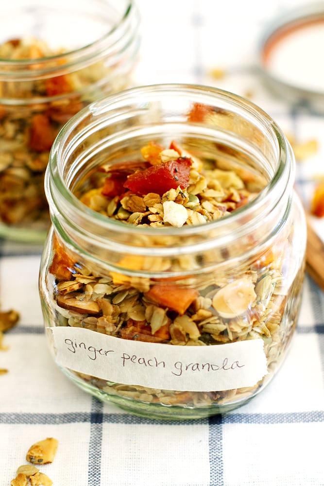 ginger peach granola in glass jar on kitchen towel