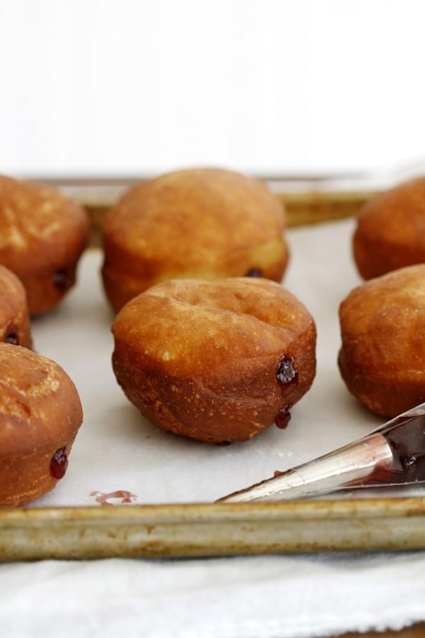 finished brioche doughnuts on baking sheet.