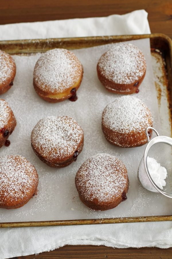 sprinkling powdered sugar on doughnuts.