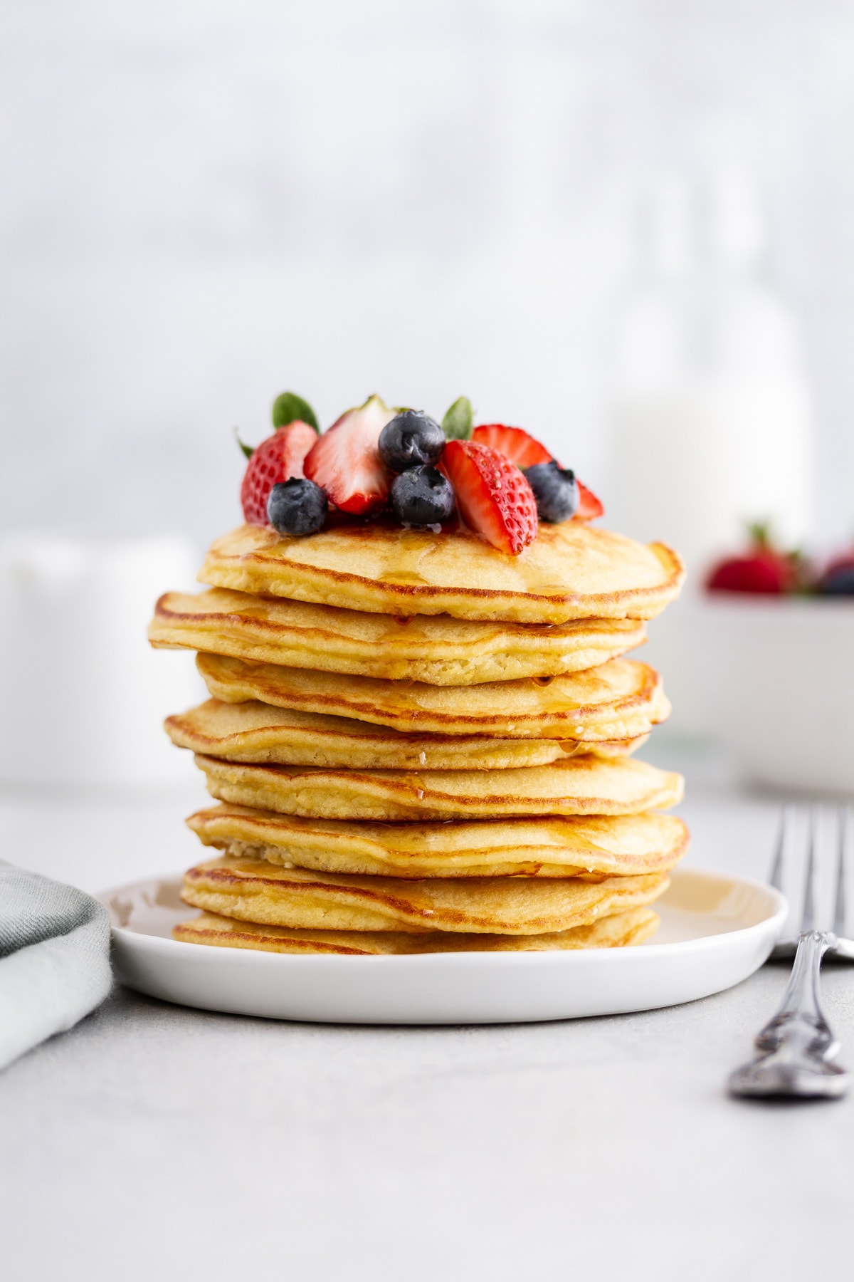 stack of coconut flour pancakes on a plate with berries on top