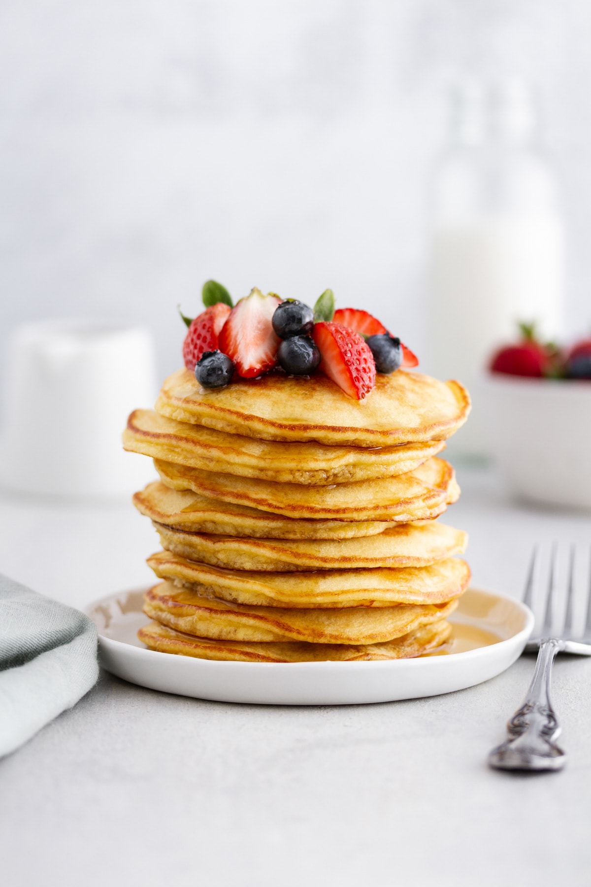 stack of coconut flour pancakes on a plate with berries on top