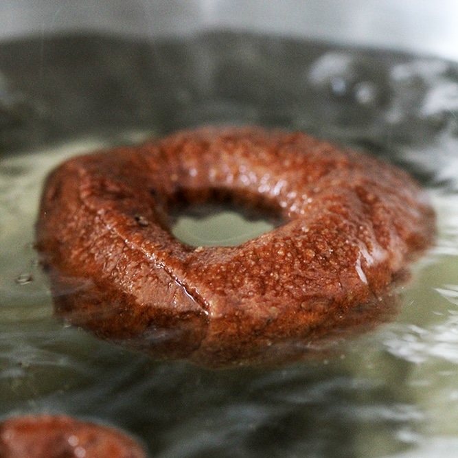 pumpernickel bagel boiling before baking.