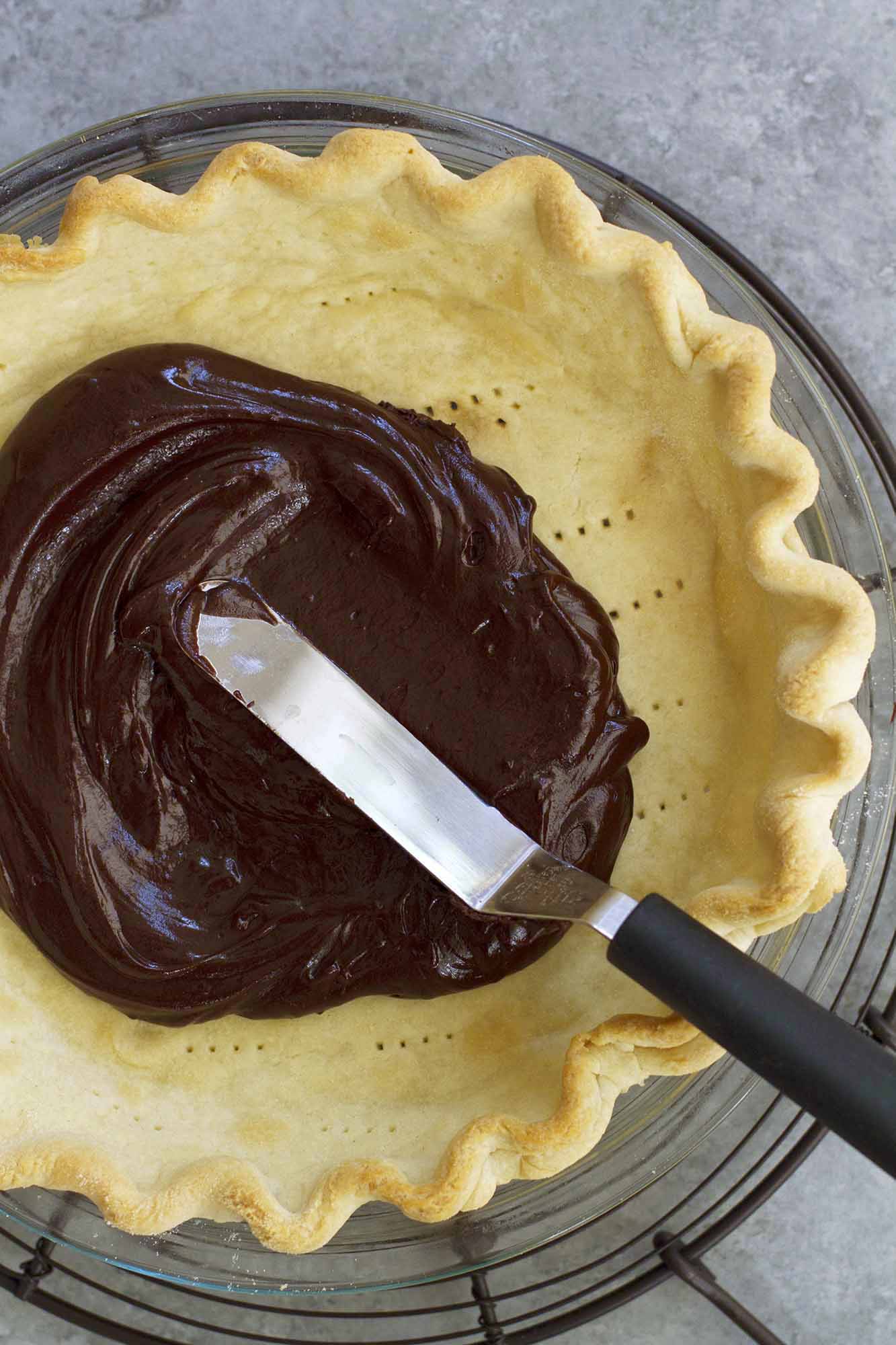 spreading chocolate over pie crust