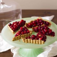 nut crusted cranberry tart on cake stand