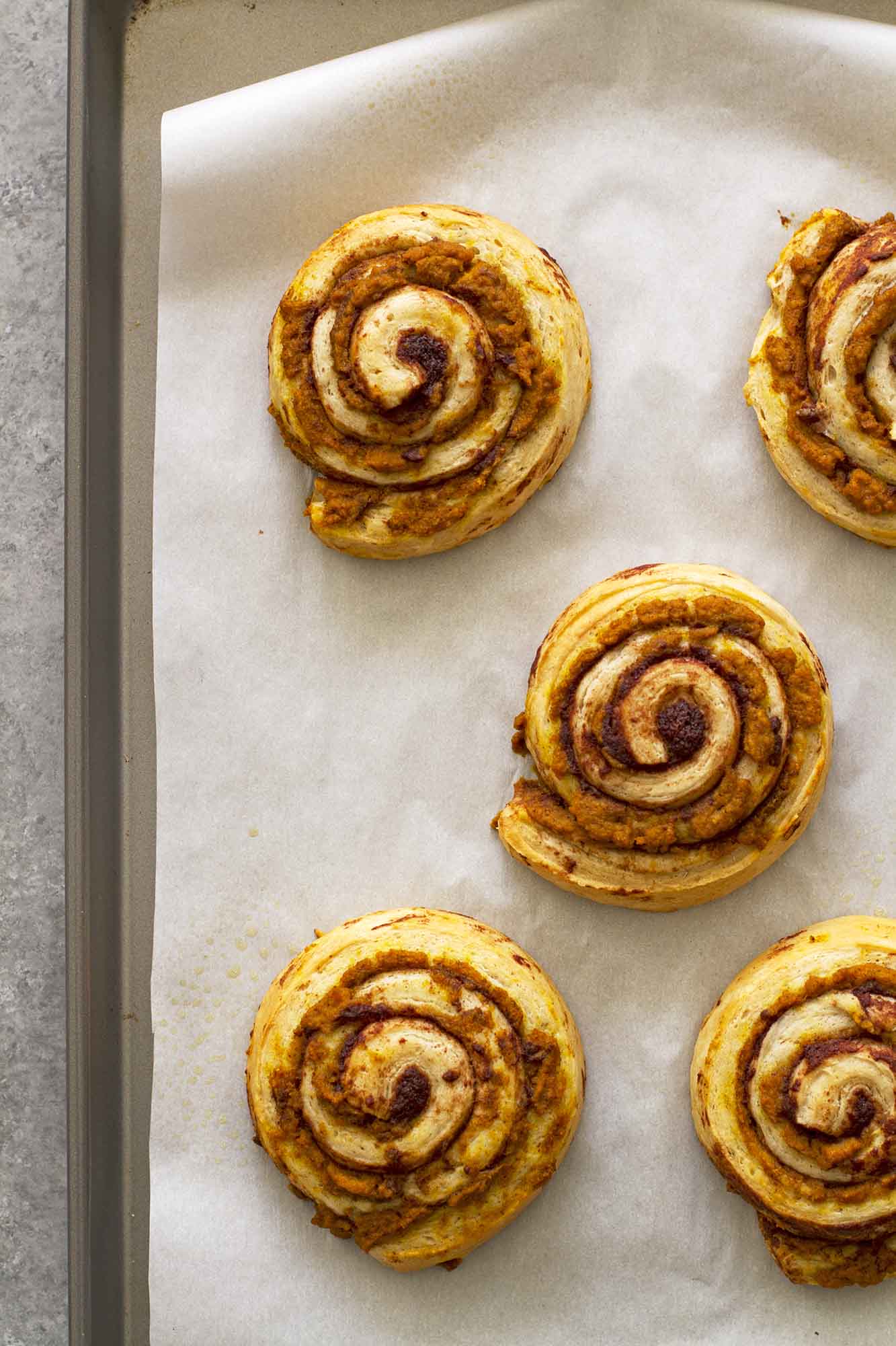 brown butter pumpkin cinnamon rolls ready for baking on parchment paper baking sheet