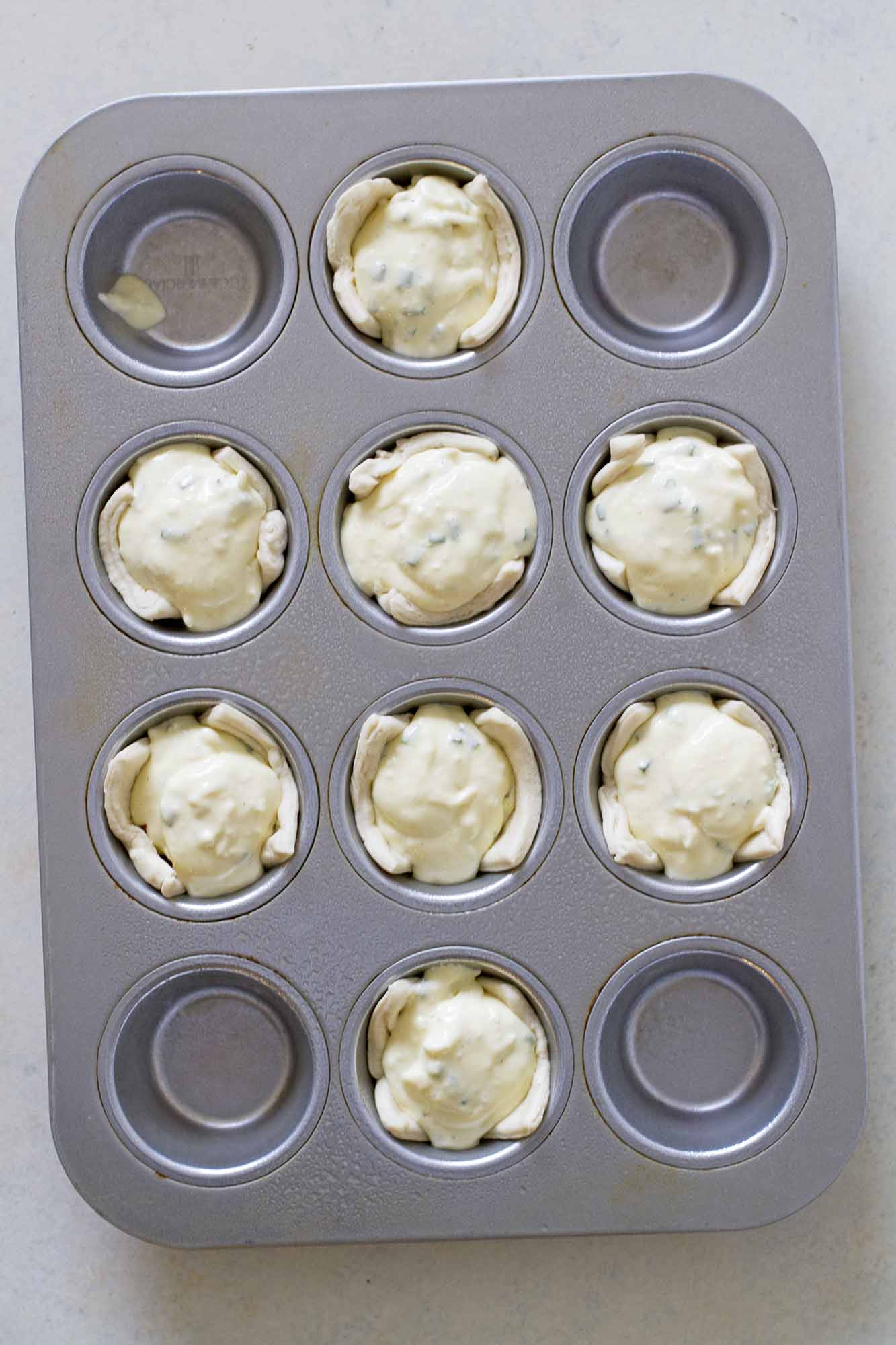 filling crescent cups in baking pan