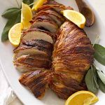 bacon wrapped maple bourbon turkey breast on baking dish.