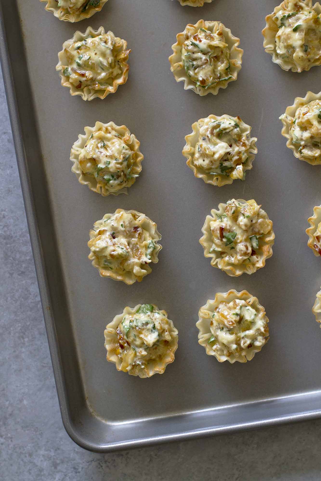 french onion tartlets on baking sheet