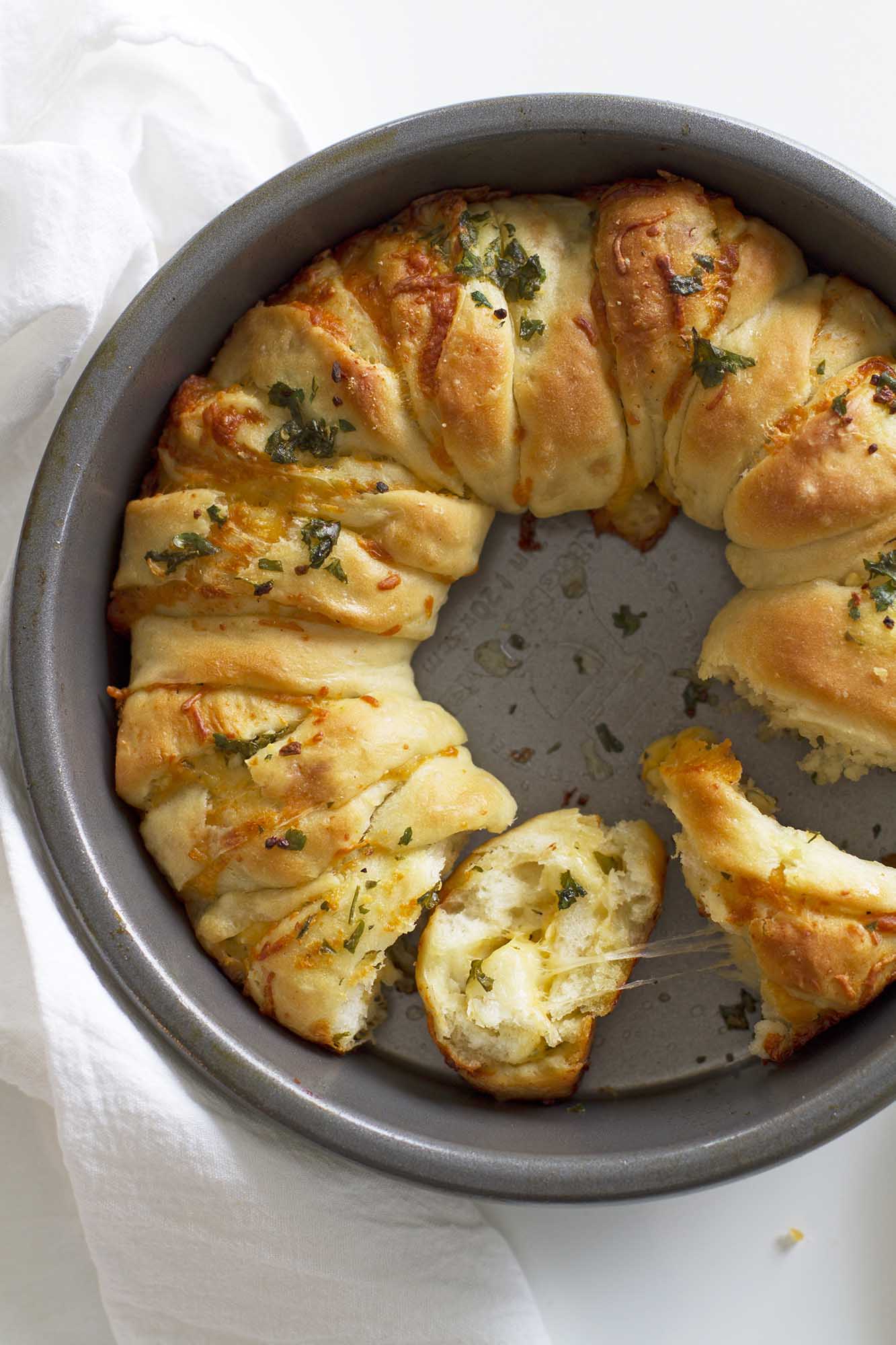 slice of garlic herb pull apart bread in baking dish