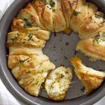 cheesy garlic herb pull apart bread in a baking dish.