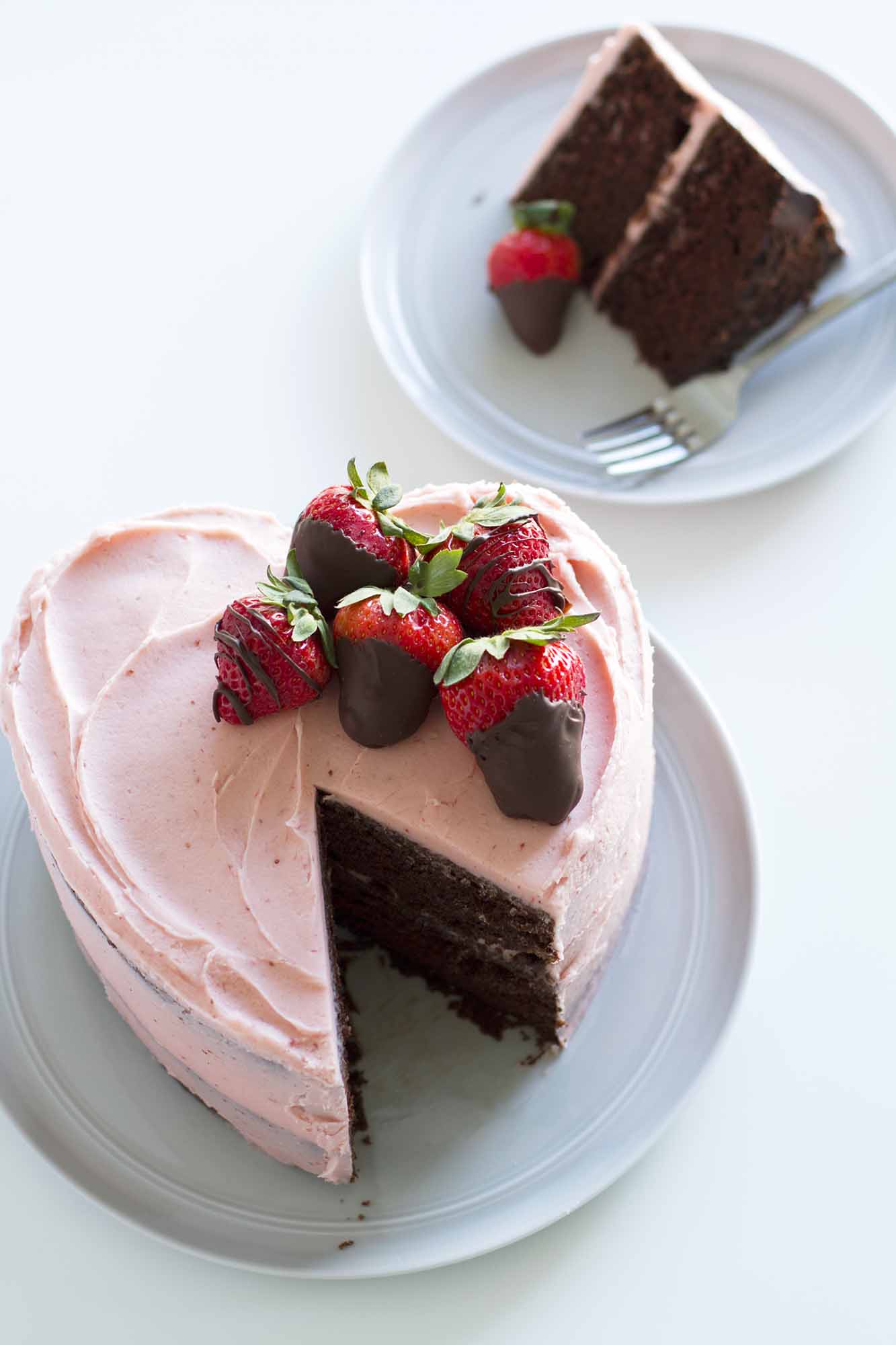 slice of heart shaped chocolate strawberry cake on a plate.