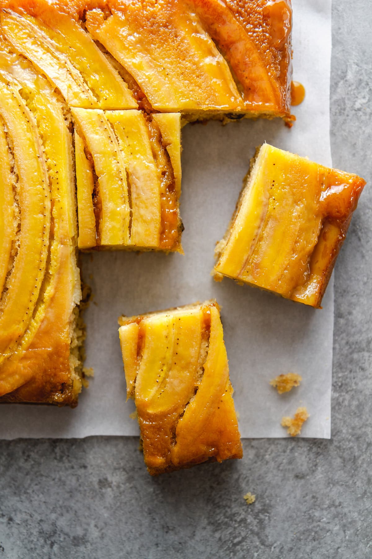 slices of bananas foster upside-down cake on parchment paper