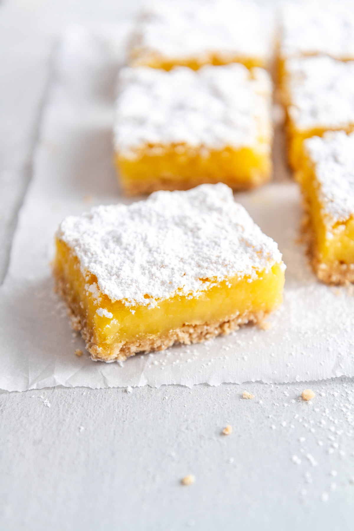 a gluten free lemon bar on a sheet of parchment paper