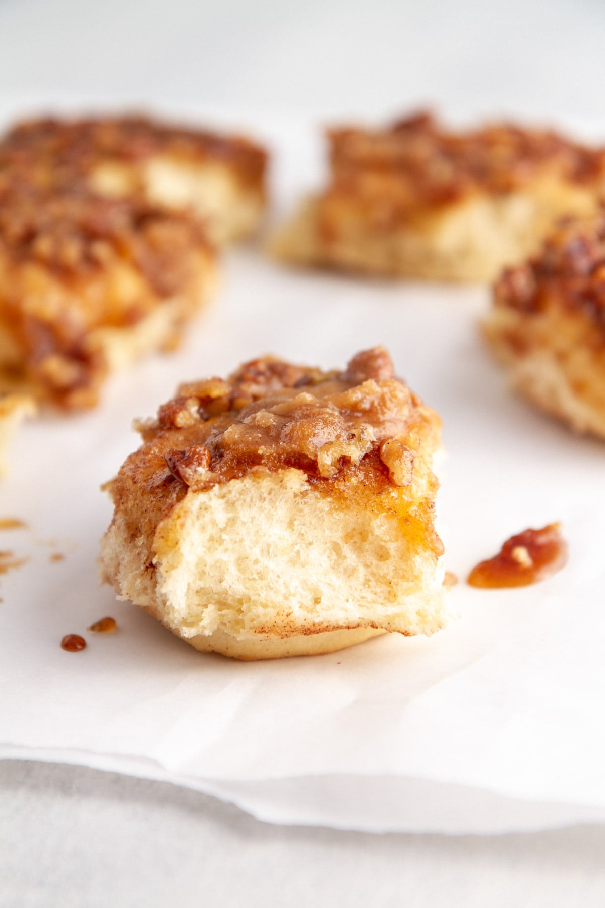 close up caramel pecan sticky bun on parchment paper