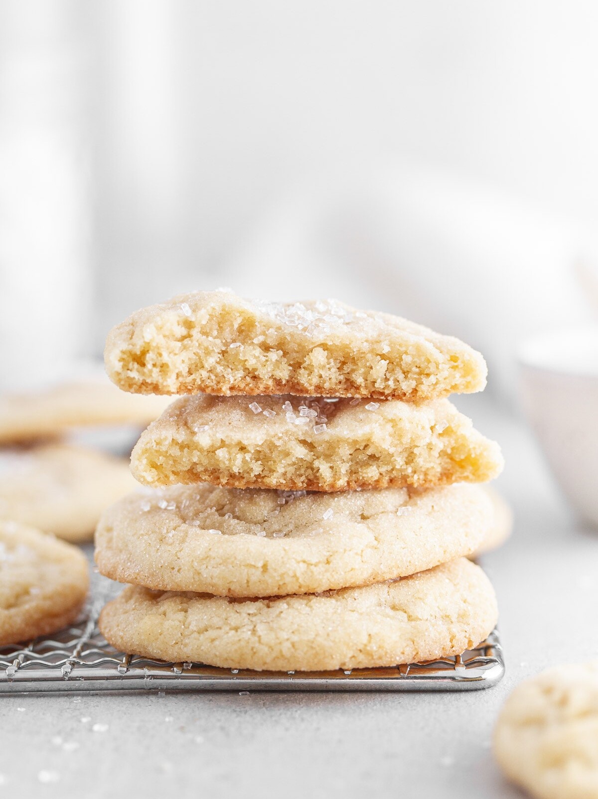 chewy sugar cookies stacked on top of each other on a cooling rack