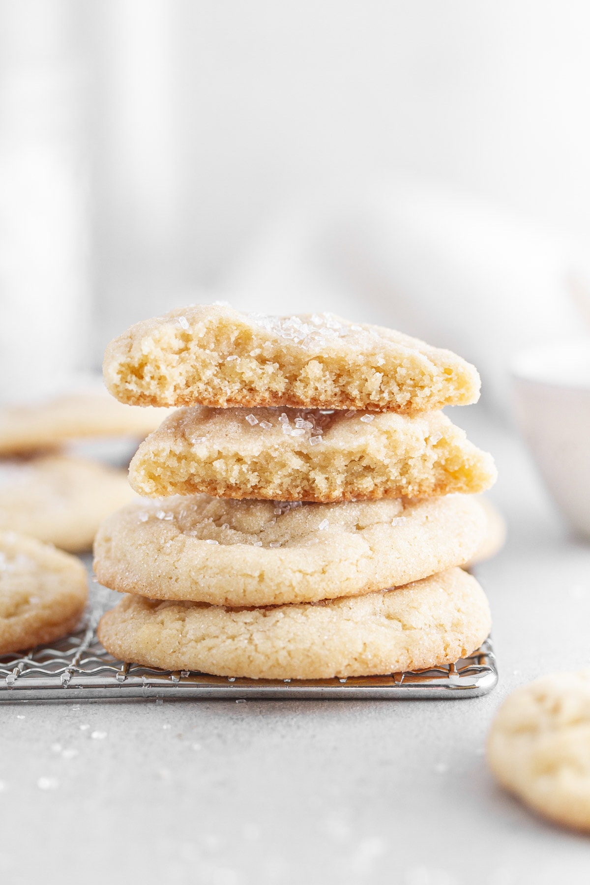 chewy sugar cookies stacked on top of each other on a cooling rack