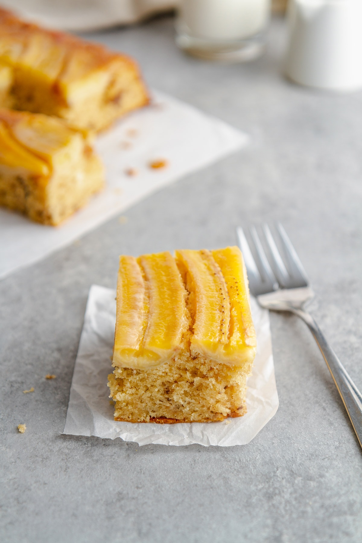 a slice of bananas foster upside-down cake with a fork next to it