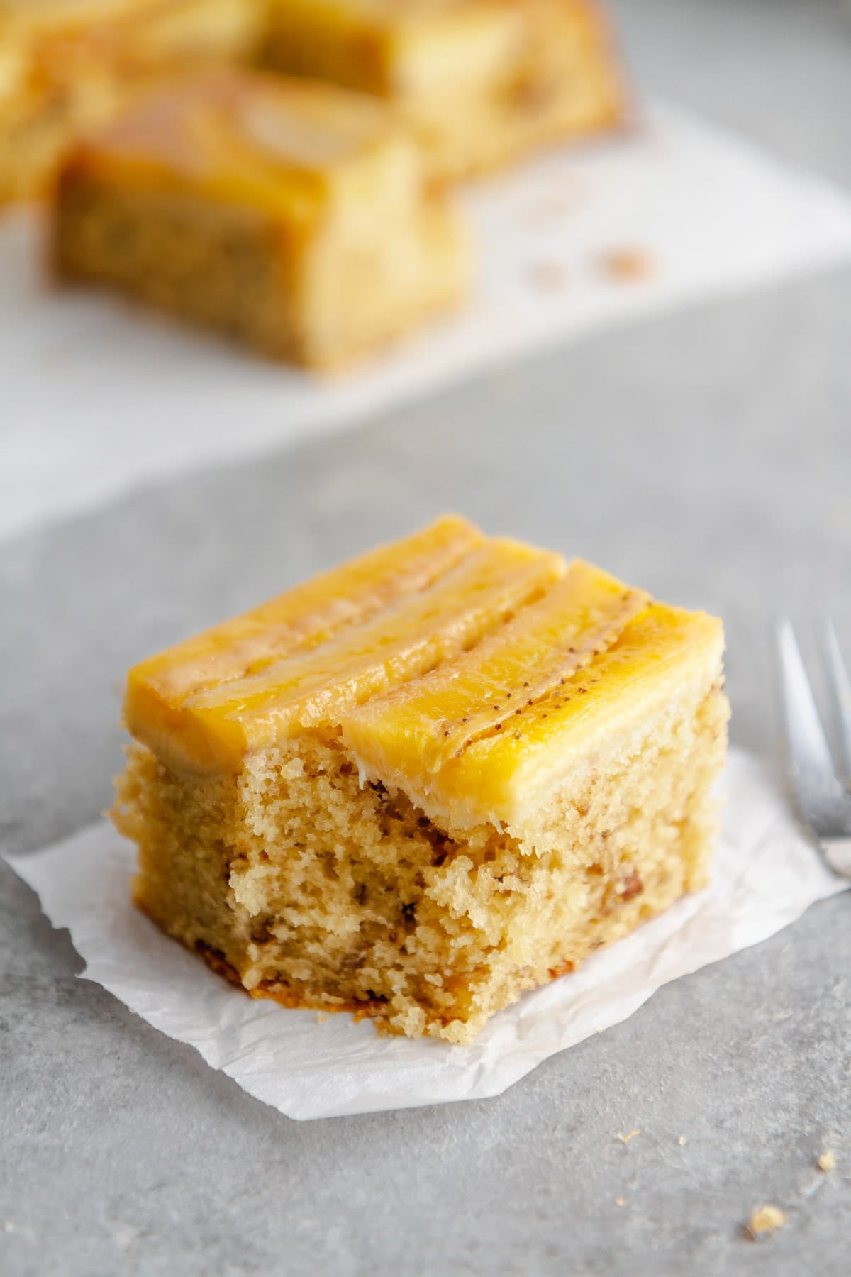 a slice of bananas foster upside-down cake with a piece taken out of it