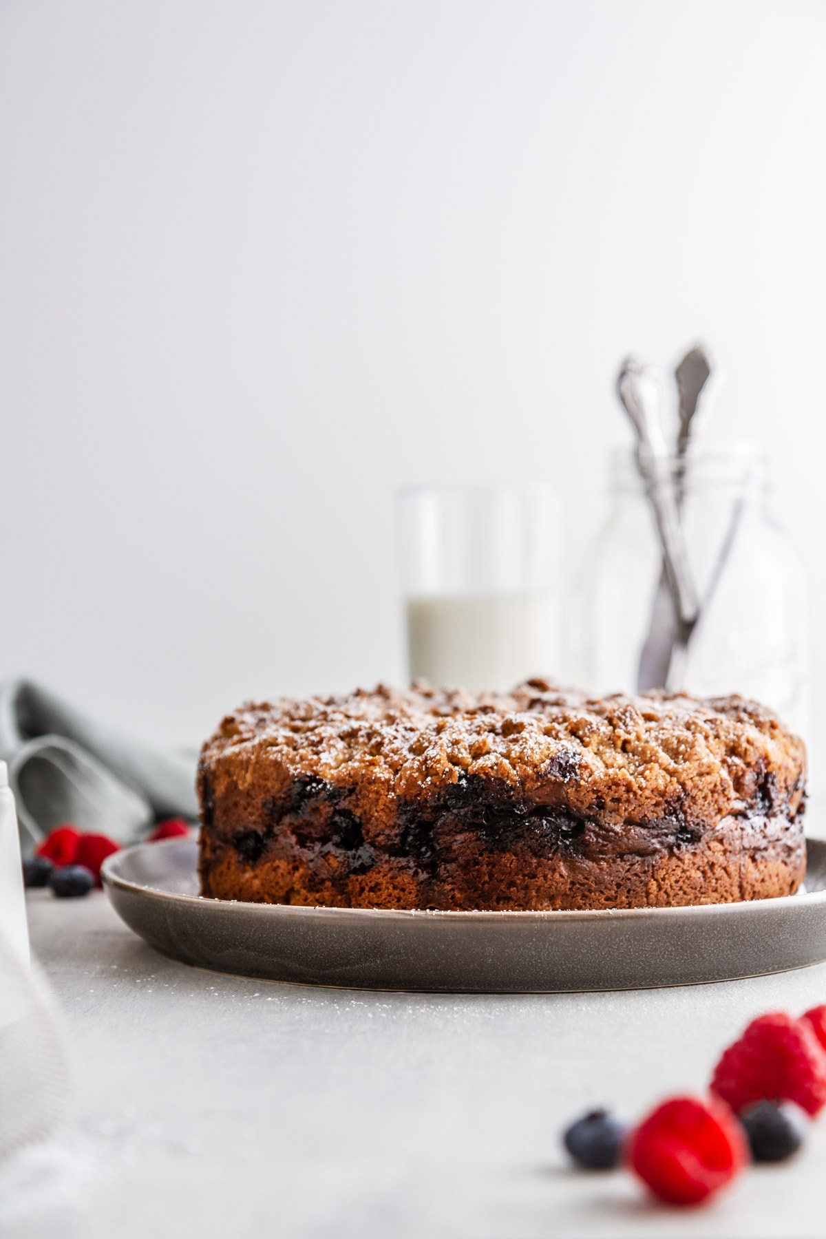 berry cream cheese coffee cake on a plate with berries in front of it