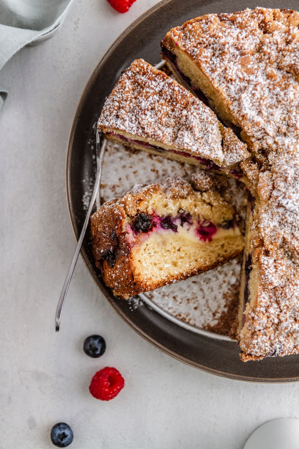 an overhead shot of a slice of berry cream cheese coffee cake