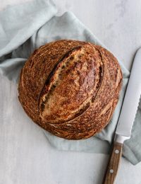 a loaf of sourdough bread with a knife next to it
