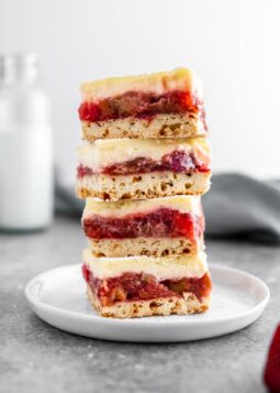 a stack of strawberry rhubarb cheesecake bars on a plate