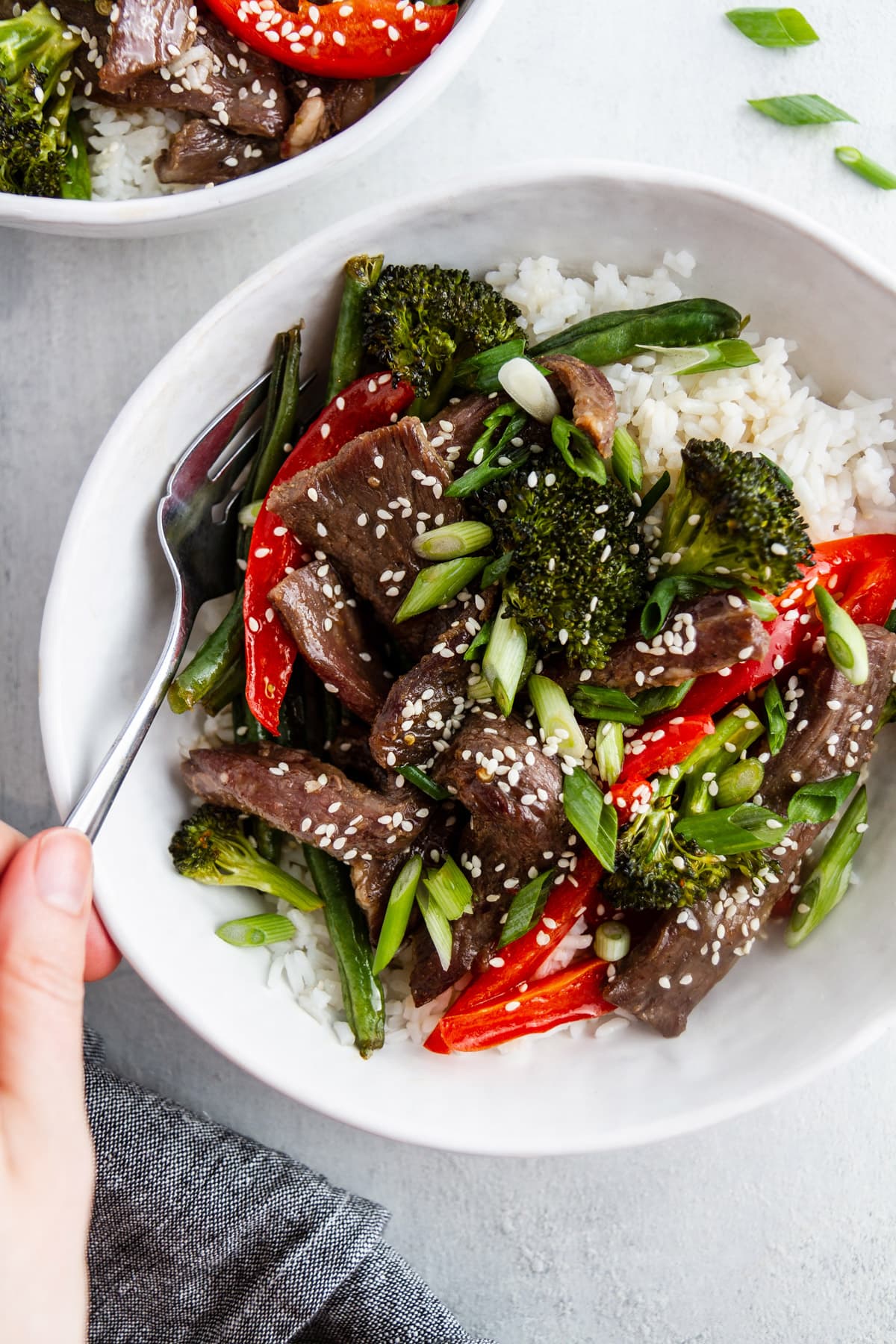 a bowl of sheet pan mongolian beef with a fork in it