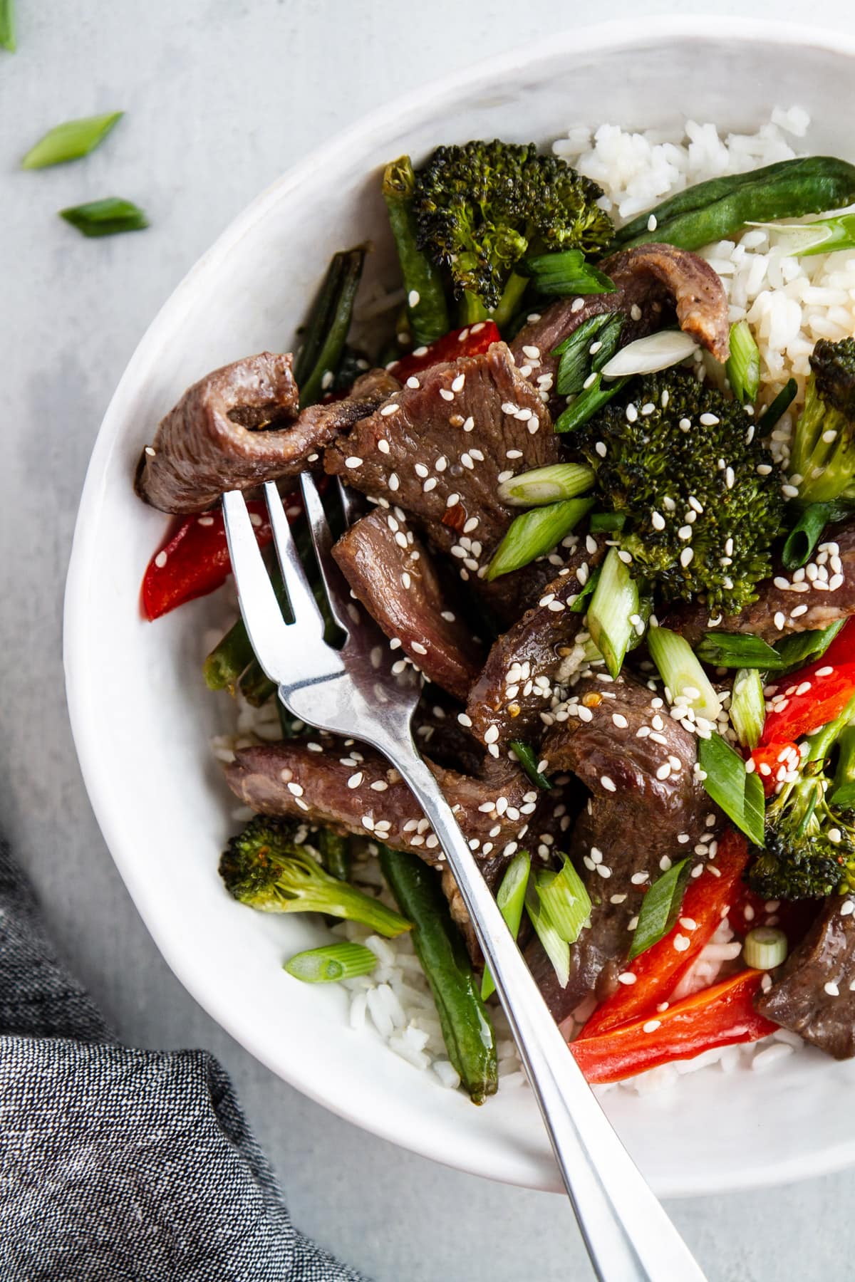 a bowl of sheet pan mongolian beef with a fork in it