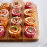 salmon pinwheels on a cutting board.