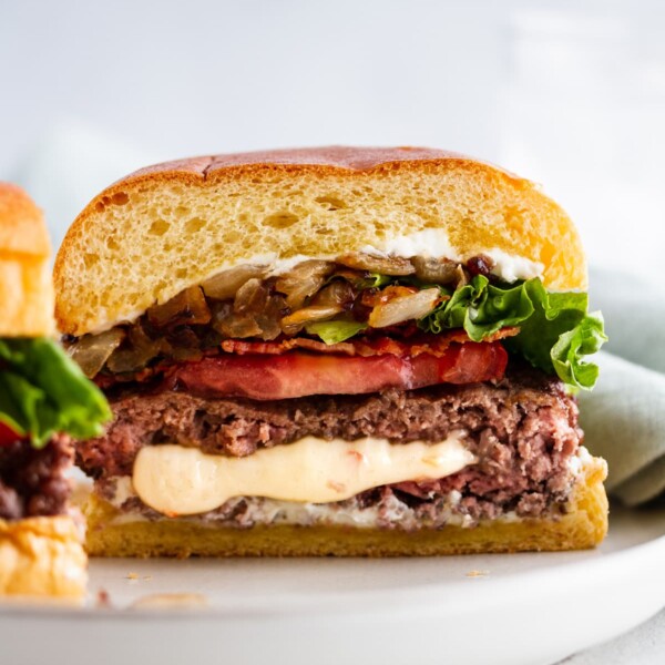 a pepper jack juicy lucy burger cut in half on a plate.